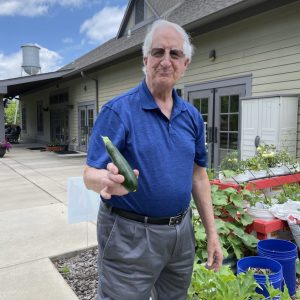 a man holding a cucumber