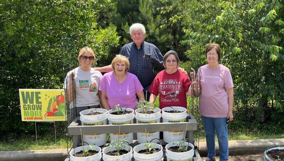 a group of people standing beside container gardens at Zion Chapel Senior Center