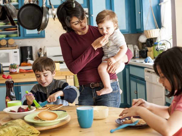 Hispanic mother and children having breakfast