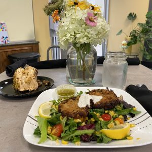 A plate of vegan crab cakes on a bed of salad at the Beautiful Rainbow Cafe.