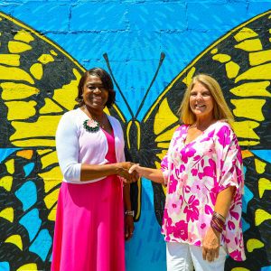 Two women pose for a photo in front of butterfly at the terrace in Linden, Alabama.