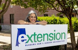 Norma Gardner posed with an Extension sign outside of the Morgan County Extension office.