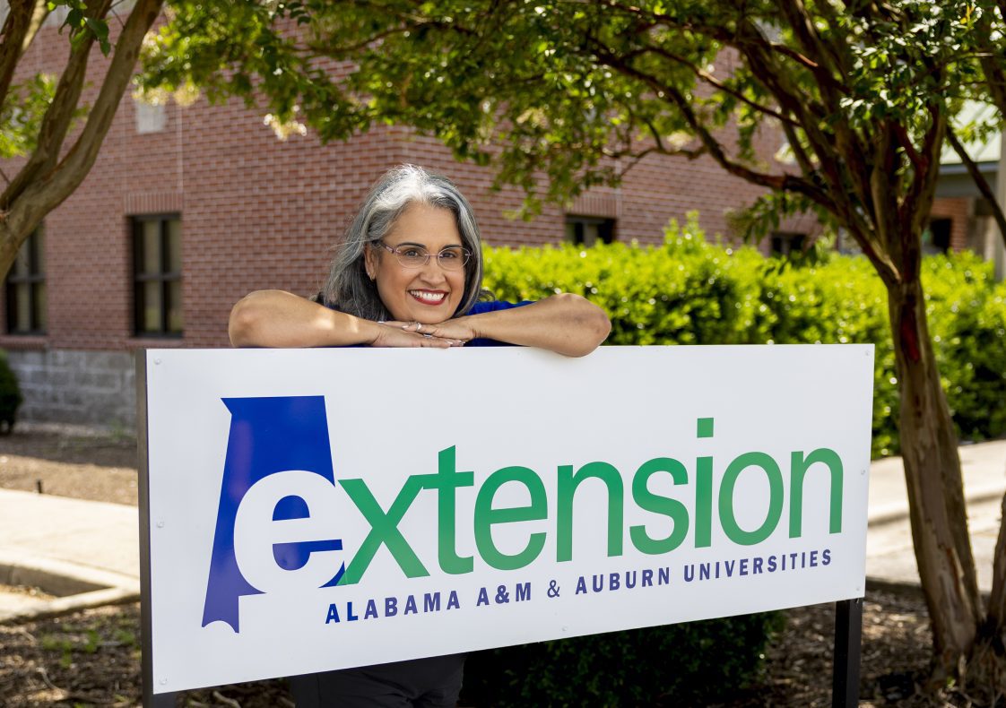Norma Gardner posed with an Extension sign outside of the Morgan County Extension office.