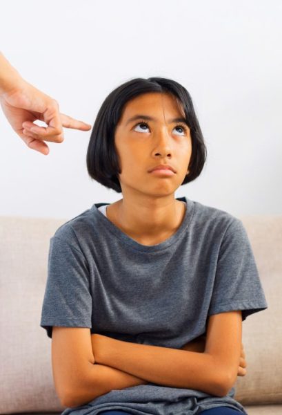 Asian mother is angry and scold her daughter while sitting on the sofa because of bad behavior. The concept of domestic violence, Stubborn child