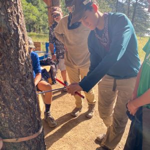 Boy scouts that are getting hands-on with forestry measurement tools.