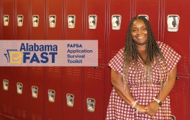 A picture of Kwan Robinson leaning against a set of student lockers with the Alabama FAST logo.