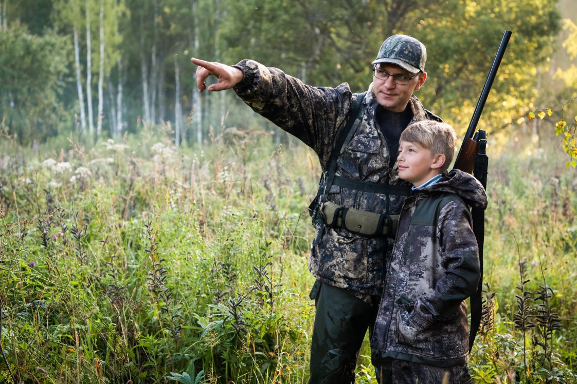 A father teaching his son how to safely hunt.