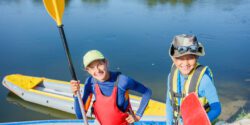 Portrait of two kids enjoying kayak ride on beautiful river.