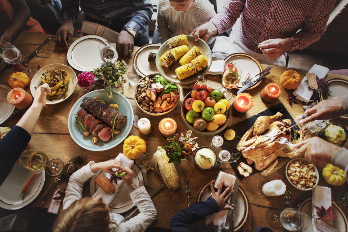 A family sharing a Thanksgiving food spread.