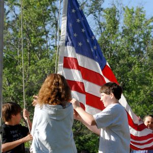 4-H members raising an American Flag.