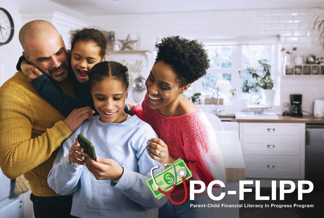 A mother and father stand in a kitchen with their two young children.