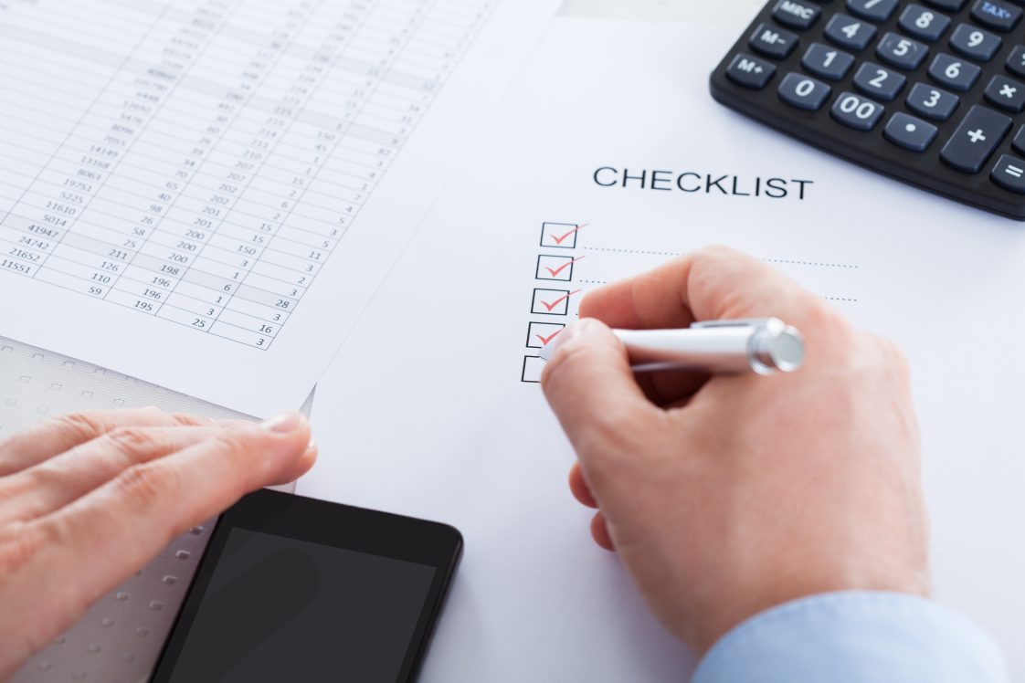 A person checking off items on a checklist for tax time.