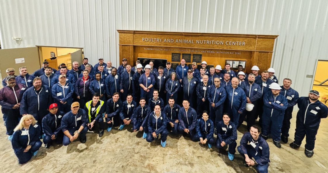 A large group of people in blue disposable coveralls at the Poultry and Animal Nutrition Center. 