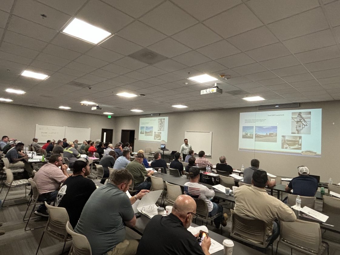 A group of people in a conference room attending a feed mill workshop.
