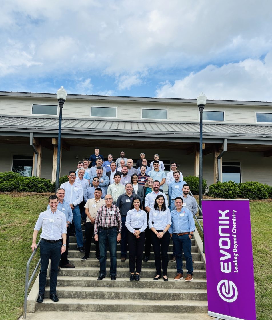 A group of people standing on steps outside a building during the feed mill workshop.