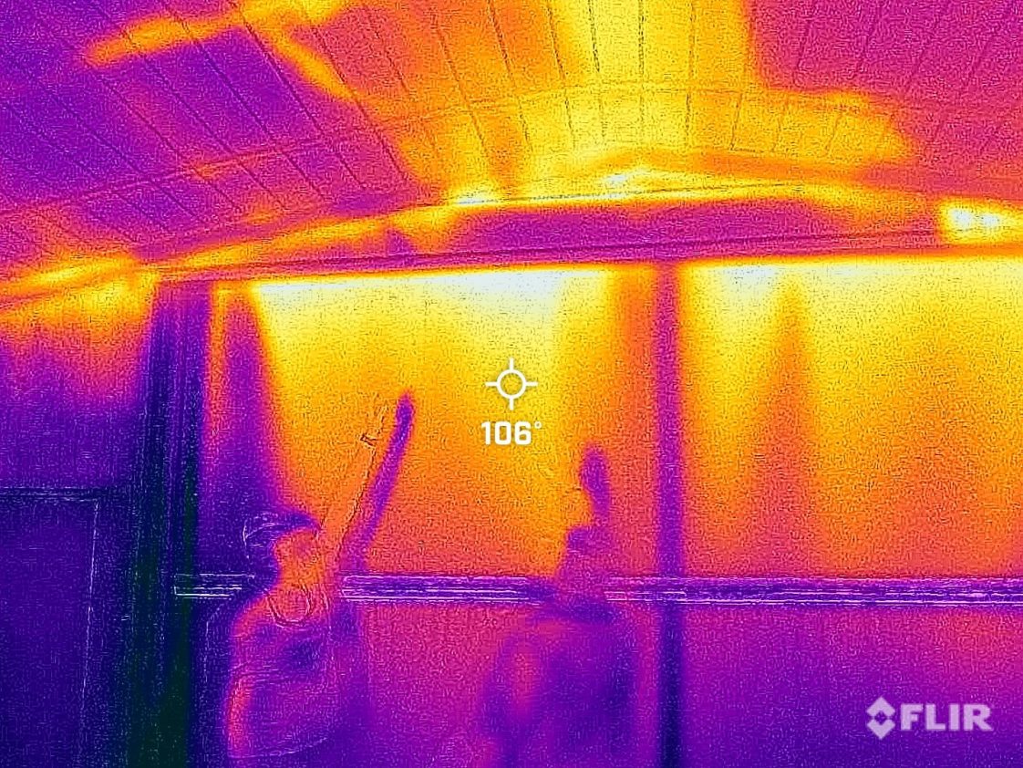 Figure 3. Can you identify the problem or problems in this thermal image of an end wall door? A. Top of door leaking hot air, B. No insulation in ceiling, C. Air leaking between ceiling and end wall, D. Hot air leaking through these openings would lower full tunnel wind speed and lead to additional heat gain from missing insulation, E. All the above. If you answered E (All the above), you would be correct. Once again, this house is not ready for hot weather and might not pass a house tightness test or wind speed test.