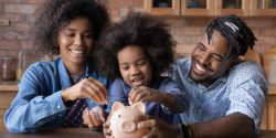 Parents and their daughter putting money in a piggy bank