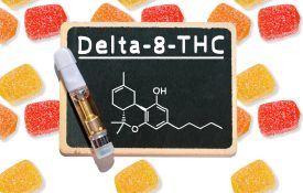 Gummy candies on a white background with a chalkboard that has the words "Delta-8-THC" written on it.