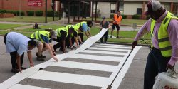 A group of people installing a crosswalk at Eutaw Primary School in Greene County, Alabama.