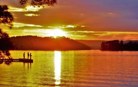 Three people fishing at sunset on Lake Guntersville.