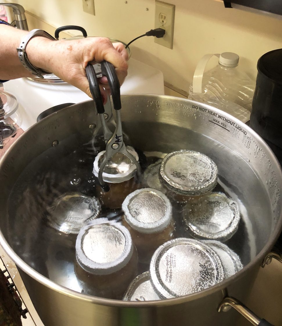A water bath canner with jars inside.