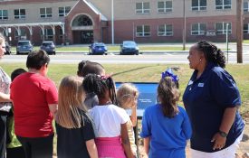 Kids reading the first page of the book on a book walk.