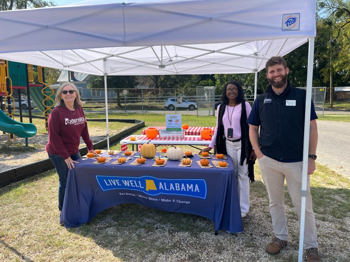 Alabama Extension employees working a booth at a farm-to-school event.