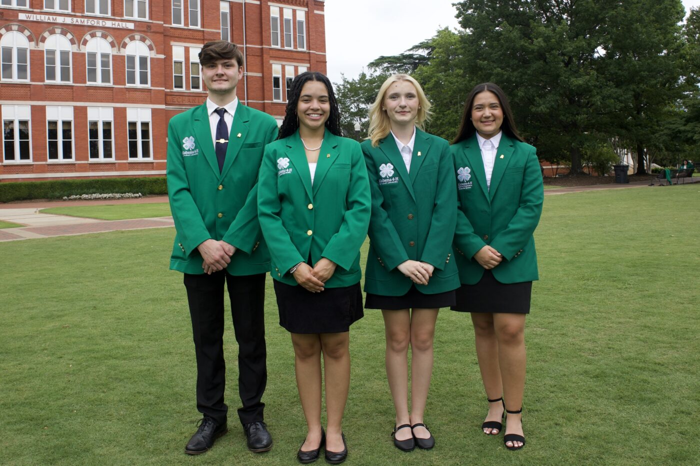 A group photo of the four 2025-2026 Alabama 4-H state ambassador officers in front of Samford Hall on the campus of Auburn University.