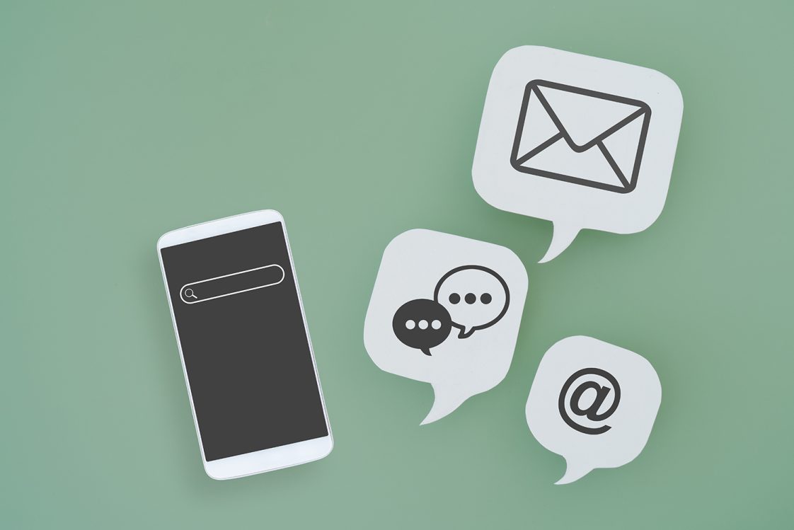 A green background with an illustrated phone and email, text, and the @ symbol icons.