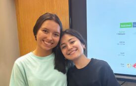 Two young girls posing for a picture at an EFNEP school event.