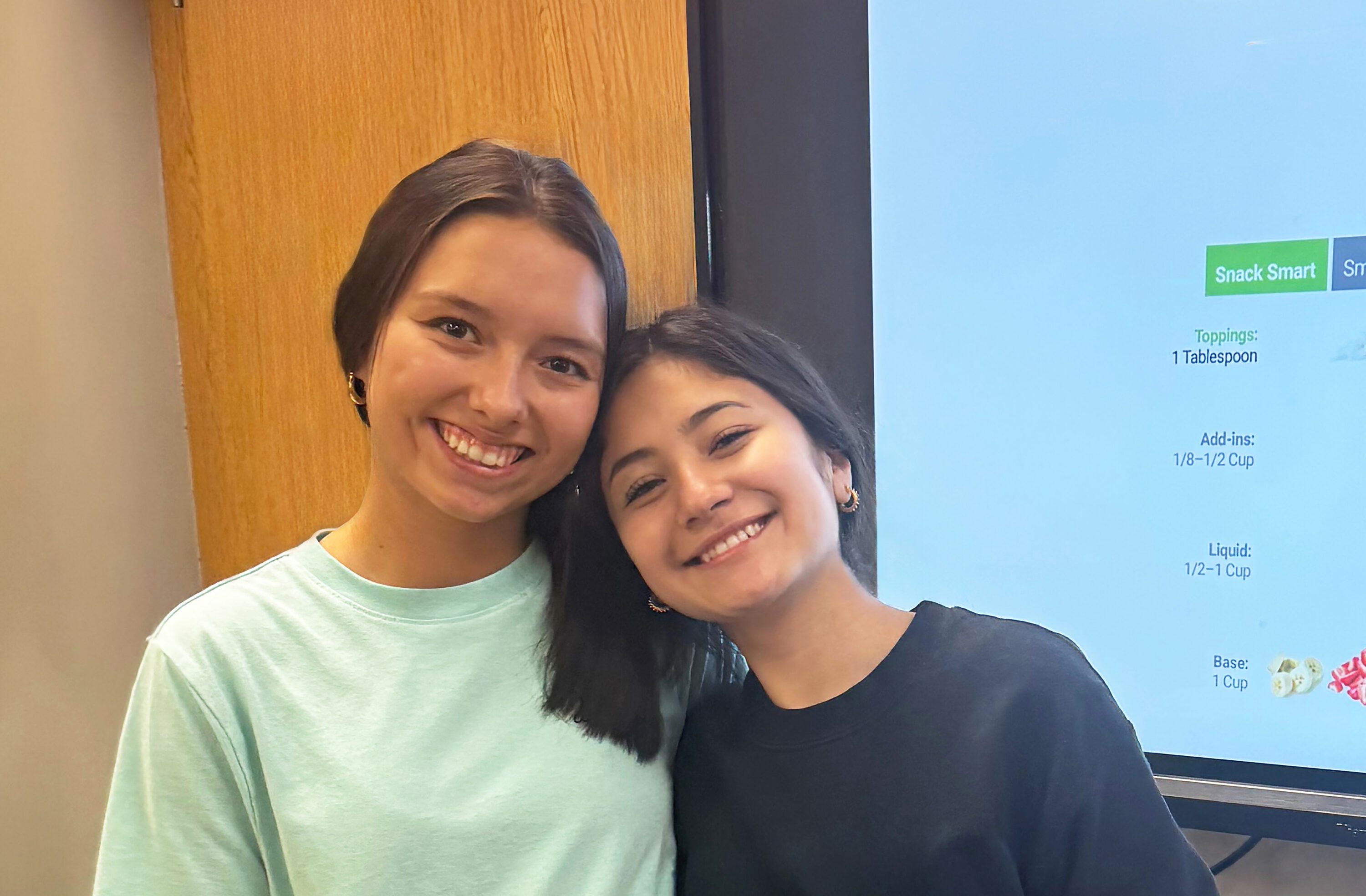 Two young girls posing for a picture at an EFNEP school event.