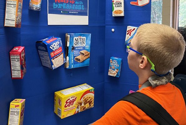 A young boy looking a display of popular breakfast foods.