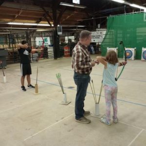 Tim Gothard, demonstrating proper archery form, working with 4-H members at a Shooting Sports event.