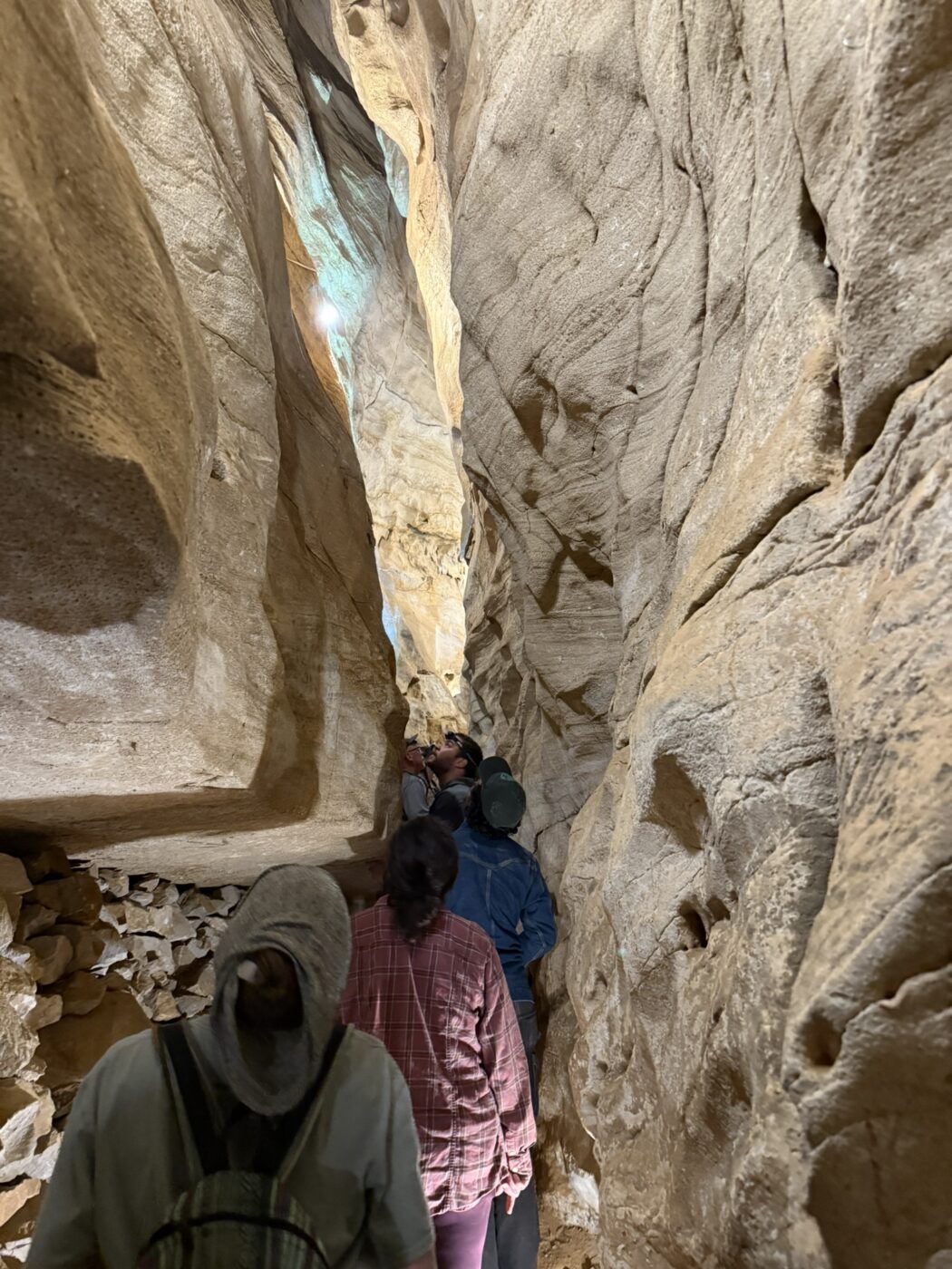 A group walking through a cave - taken from the back of the line.