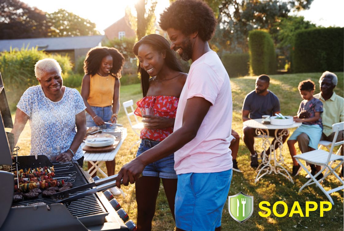 An African American family grills food for a family barbecue,