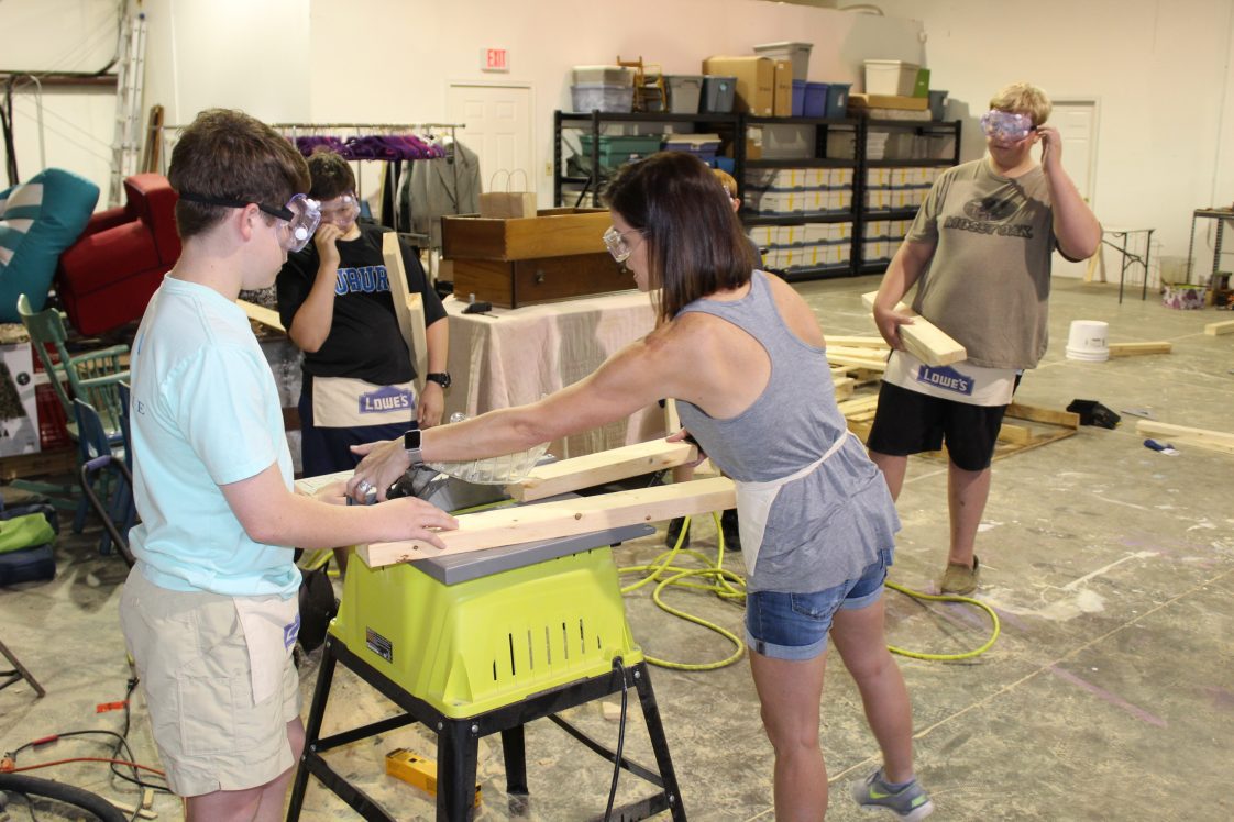 Lee County Annual Report - A female teacher shows two middle school students how to use power tools including a tablesaw. ACES-2845