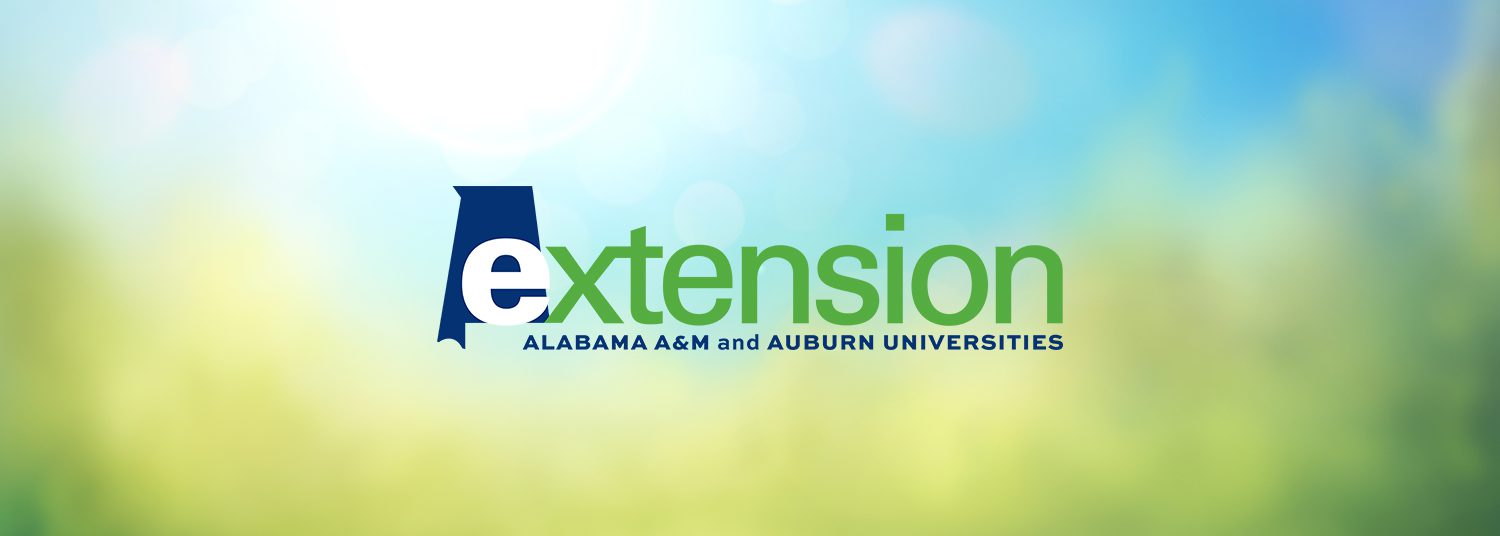 The Alabama Extension logo on an abstract blurred background illustration of a summer blue sky with lush green foliage of trees, bushes and grass