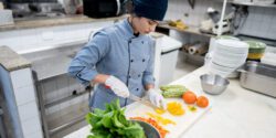 Chef chopping vegetables in a commercial kitchen