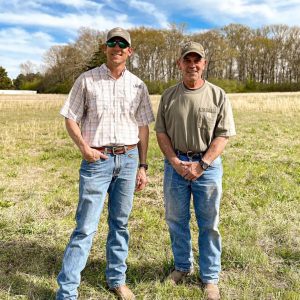 David Russell and a farmer standing in an open field.