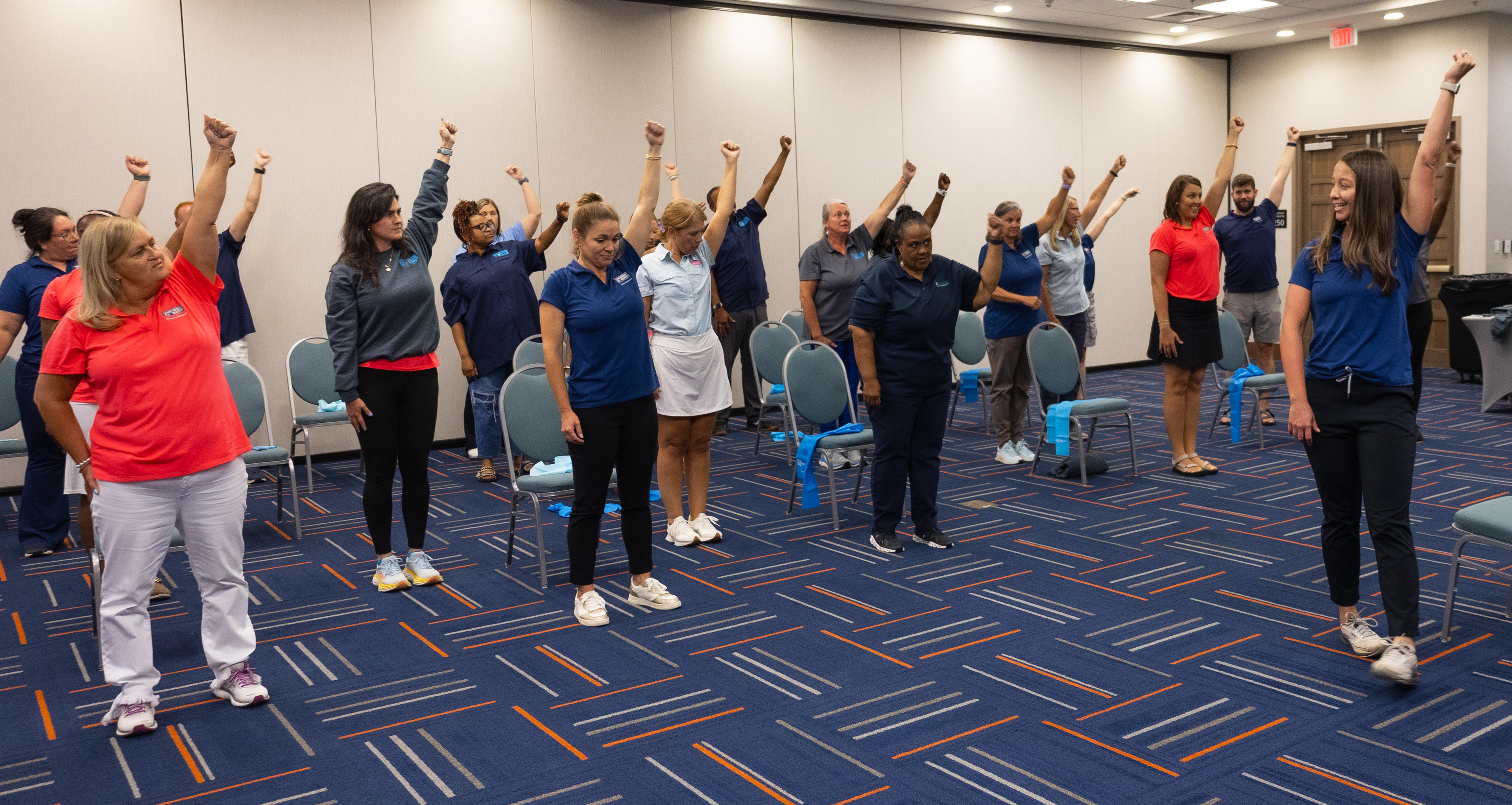 A room of adults doing resistance-band exercises.