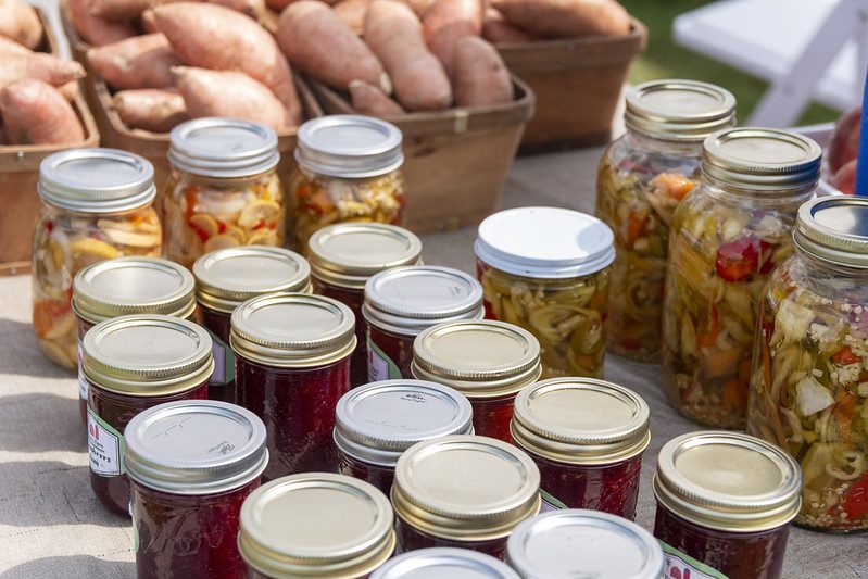 Jars of preserved food for sale at a farmers market.