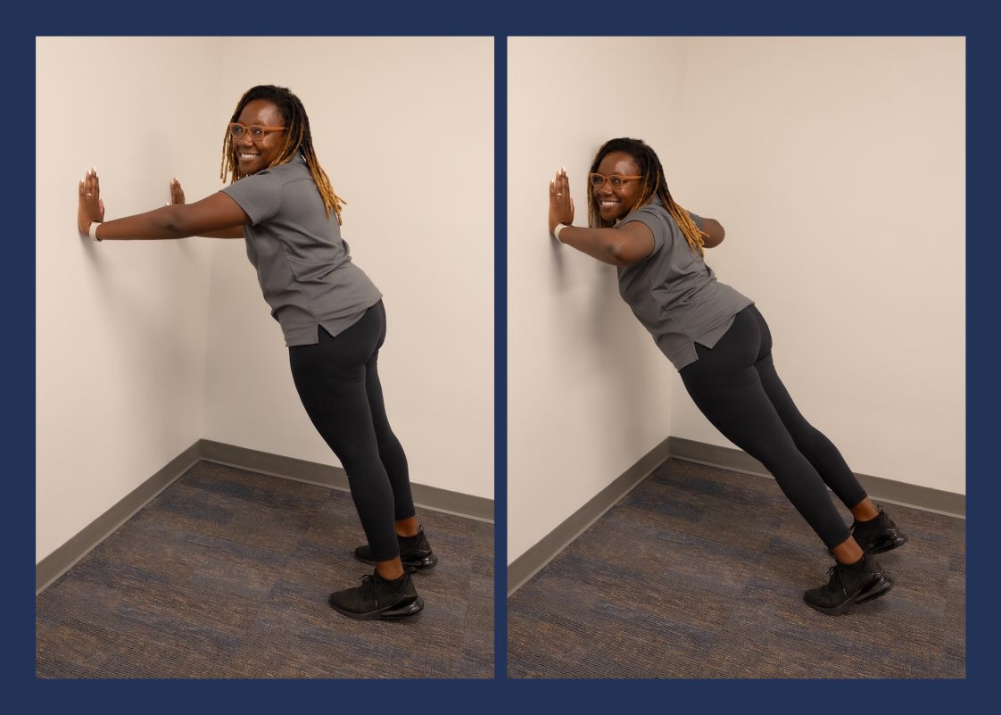 A woman demonstrating the wall push-up exercise.