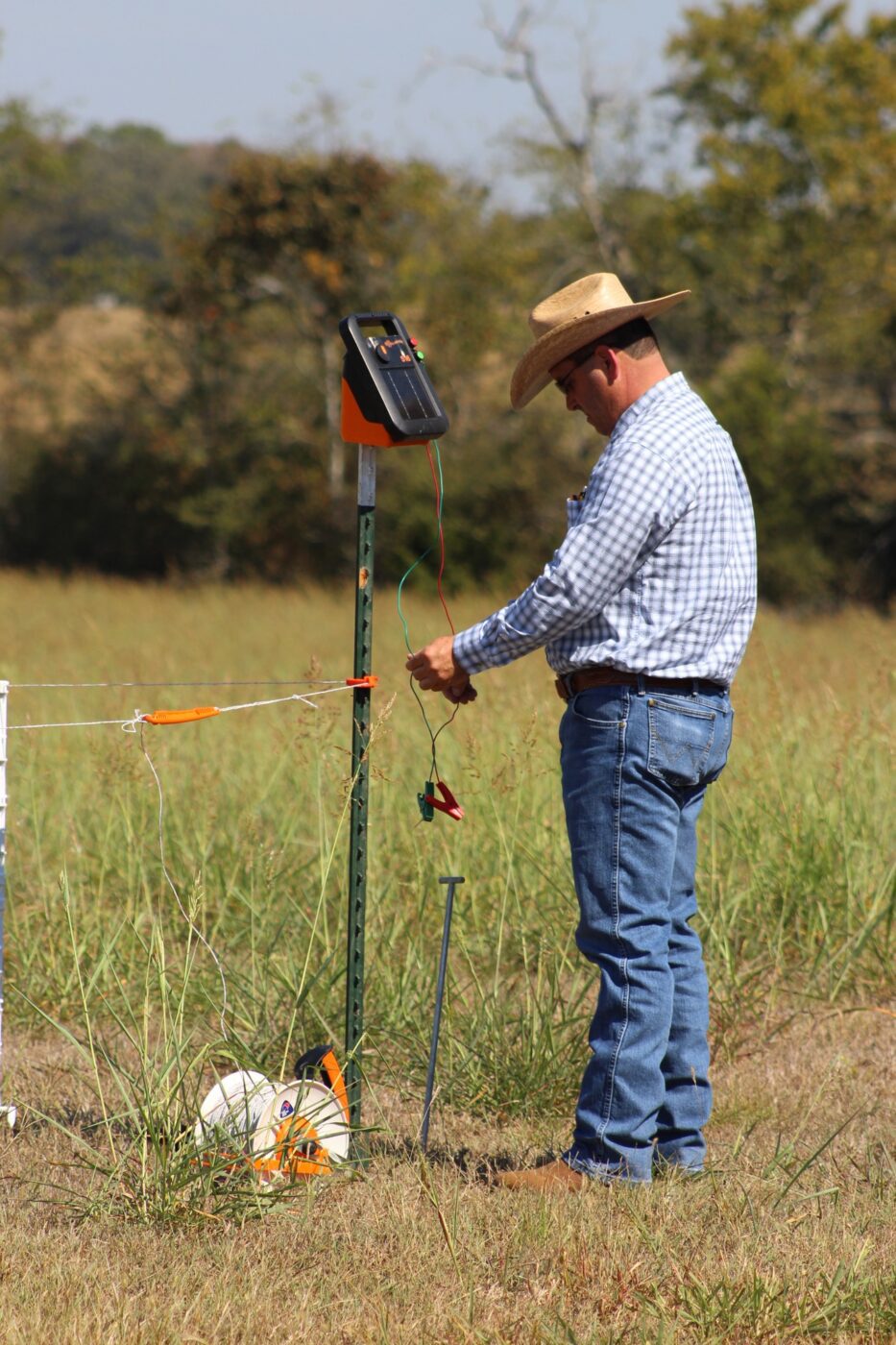 Extension specialist Kent Stanford setting up temporary fencing in a pasture. 