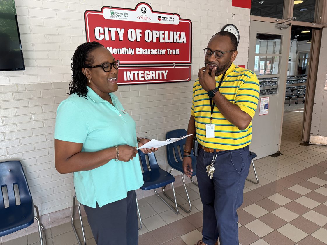 A candid image of Regina Meadows and Tamarcus Milner talking and laughing at Opelika Learning Center.