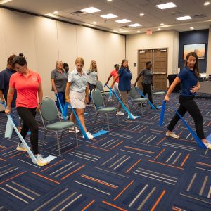 A room of adults doing resistance-band exercises.