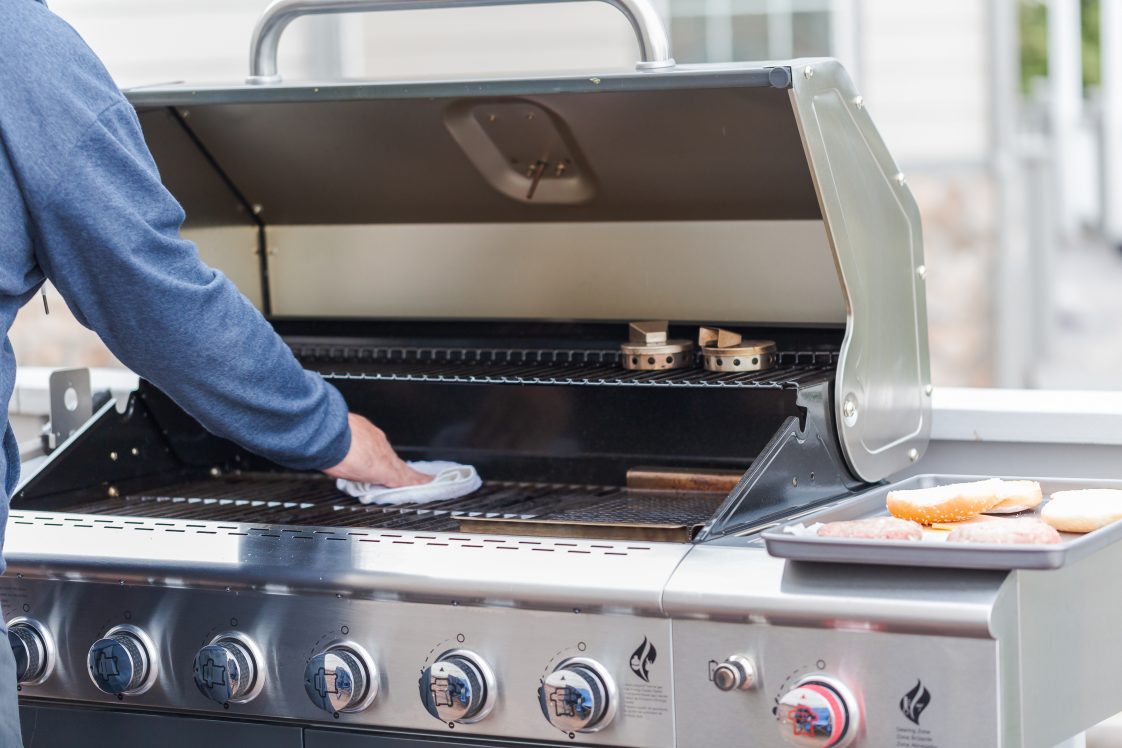 a hand cleaning a grill
