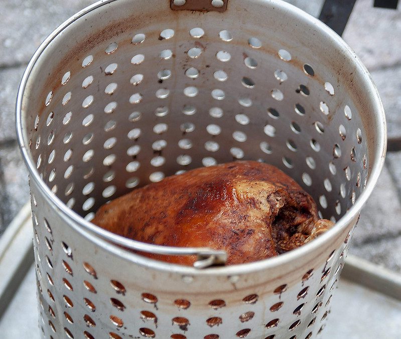 A turkey inside a deep-fryer basket.