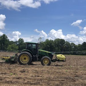 A tractor in a field planting.