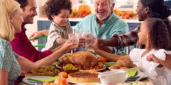 Multi-generation family celebrating Thanksgiving at home, eating a meal together.