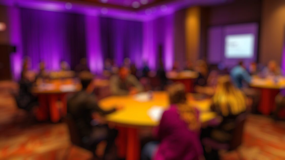 A blurry image of people at a conference award ceremony.